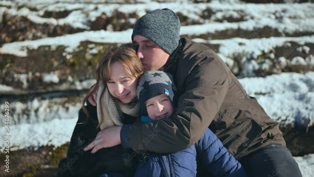 Parents embrace their son in the sunny winter weather. Parents embrace their son in the sunny winter weather.