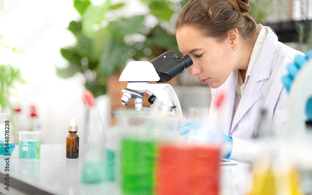 Female scientist working in medical biotechnology research laboratory using microscope for advanced chemistry analyzing. Doctor woman experiment vaccine innovation in microbiology development lab. Female scientist working in medical biotechnology research laboratory using microscope for advanced chemistry analyzing. Doctor woman experiment vaccine innovation in microbiology development lab.