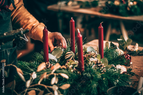 preparation of traditional advent wreath with candles from natural components, pine fir and adorns