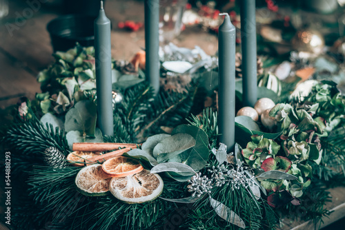 preparing traditional advent wreath with candles, baubles, natural components, pine fir and adorns