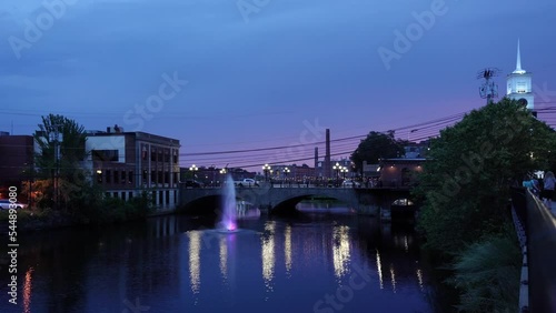 View of the Nashua River with a fountain and a bridge on Main Street against the background of the night sky in Nashua, NH
