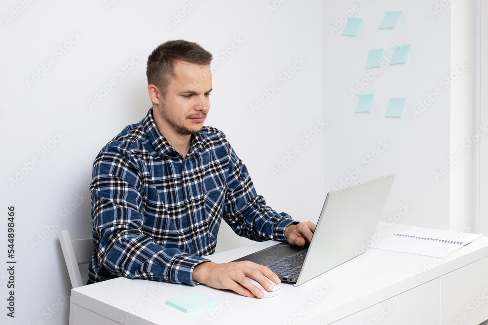 a young person using a laptop, typing on a keyboard, writing an email or message, chatting, working online at a computer. a young person using a laptop, typing on a keyboard, writing an email or message, chatting, working online at a computer.
