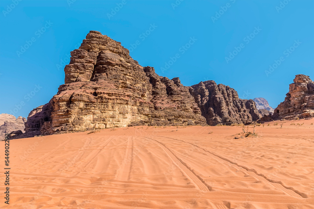 A view of vehicle tracks in the vast desert landscape in Wadi Rum, Jordan in summertime