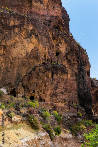 Guanchen Höhlen im braunen Bergmassiv mit Büschen besetzt