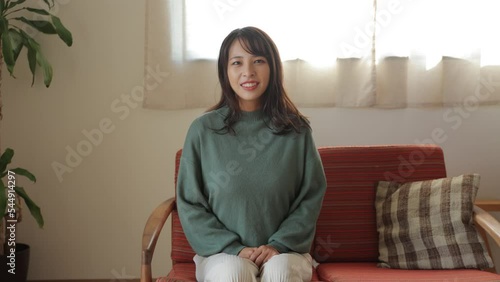 Beautiful young asian talking to the camera. Living room. 25P