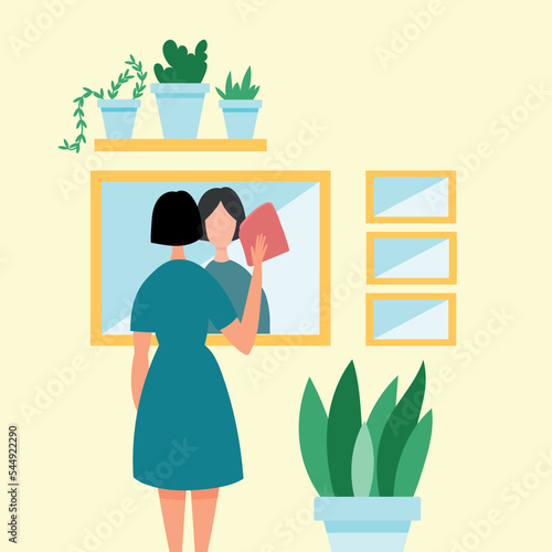 Cleaning service. The girl does housework, does the cleaning, washes a large mirror. Housewife concept. 