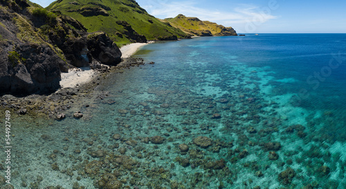 Fototapeta Naklejka Na Ścianę i Meble -  A healthy coral reef fringes the beautiful island of Gili Banta near Komodo National Park in Indonesia. This area, part of the Coral Triangle, is known for its extraordinary marine biodiversity.
