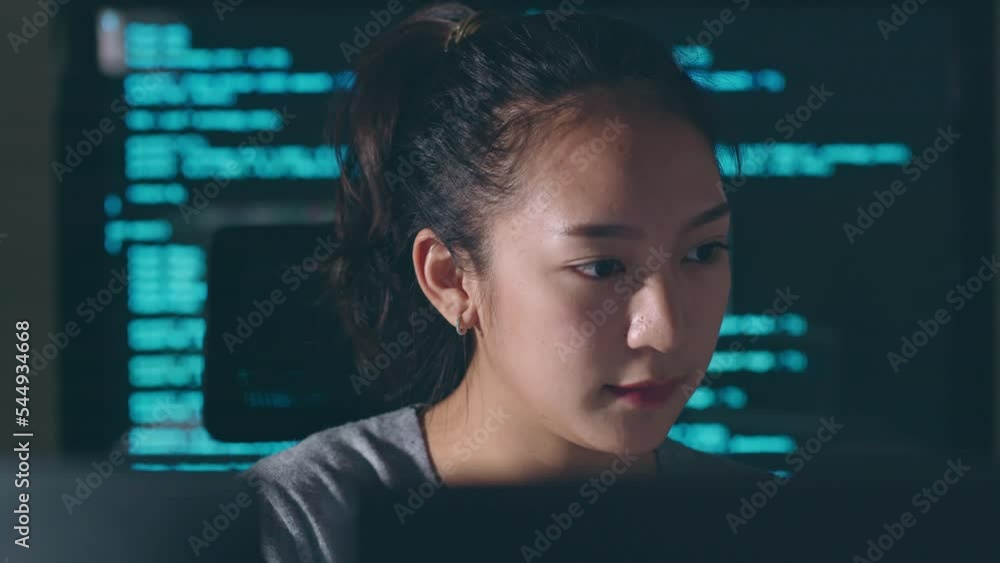Young Asian woman, developer programmer, software engineer, IT support, working hard at night overtime on computer to check coding in bugging system and running program successful.