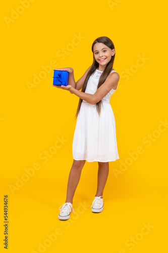 happy teen girl hold present box on yellow background