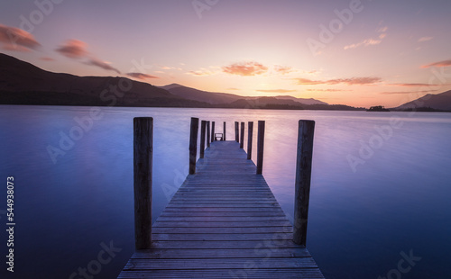 Long exposure post sunset of wooden jetty leading into a lake. Lake District Uk. Feelings of calm and relaxation