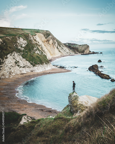 A person standing above Man of War Cove looking out to sea.  Durdle Door, Lulworth.  Dorset.  