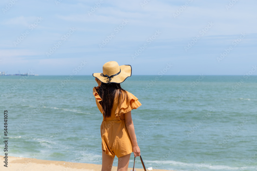 Travel woman with straw hat and look at the sea beach
