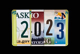 2023 writtten with US licence plates, black slate background