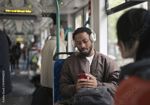 young man in the tram uses a smartphone