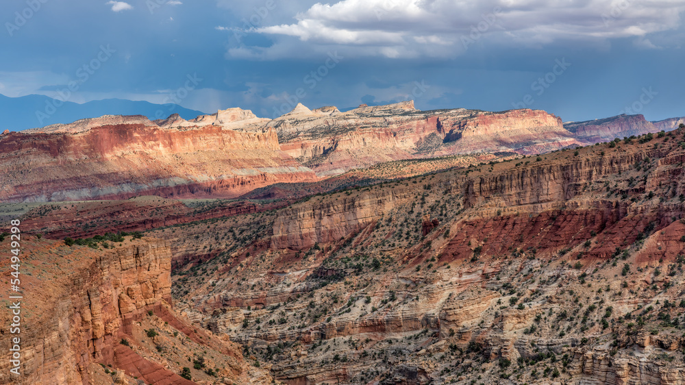 Dramatic evening lighting on the canyon from Sunset Point at the Capitol Reek National Park mountains in the distance 