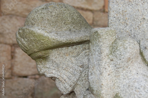 Very old pilgrim figure head sculpted on a column of a building in Tui in Portugal. photo