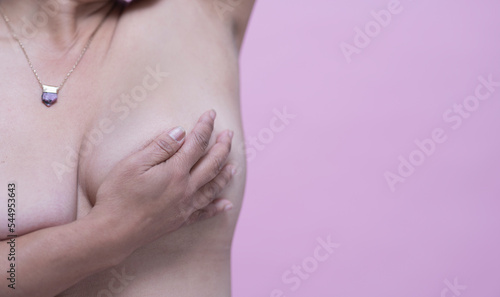 Mid section of woman doing self breast exam