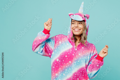 Young fun woman wear domestic costume with hoody and animals ears raise up hands look aside on area dance on pajama party isolated on plain pastel light blue cyan background People lifestyle concept photo