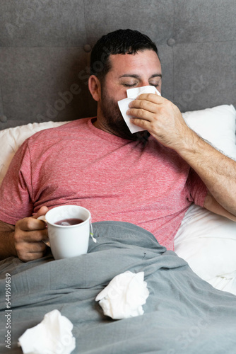 Hombre de mediana edad en cama enfermo con síntomas de gripe
 photo