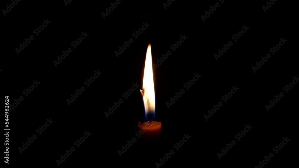 Flame from a burning thin candle. Burning candle. The candle burns in the dark. Candle flame on a black background Flame from a burning thin candle. Burning candle. The candle burns in the dark. Candle flame on a black background