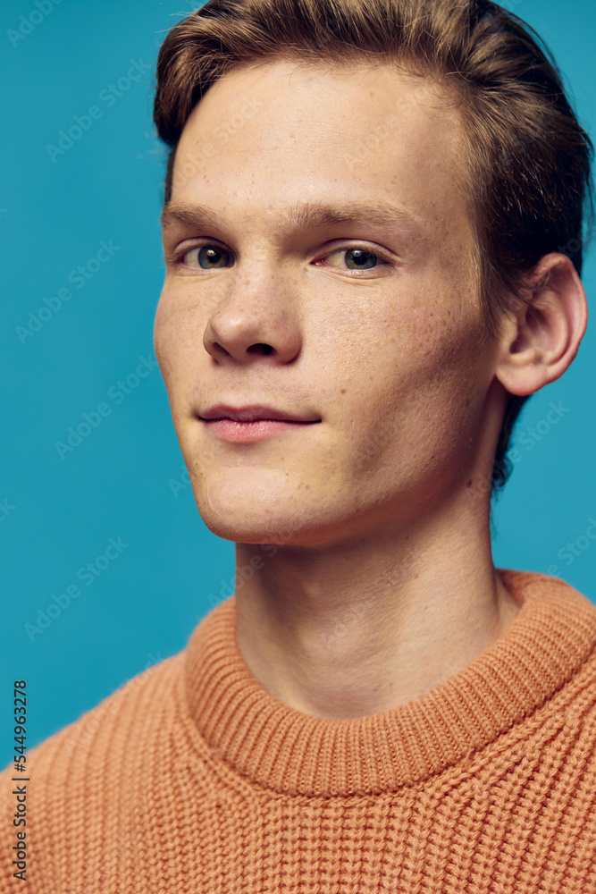 portrait of a handsome young man on a blue background in a knitted sweater portrait of a handsome young man on a blue background in a knitted sweater