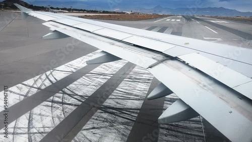 View from window of airplane taking off at airport against cloudy sky