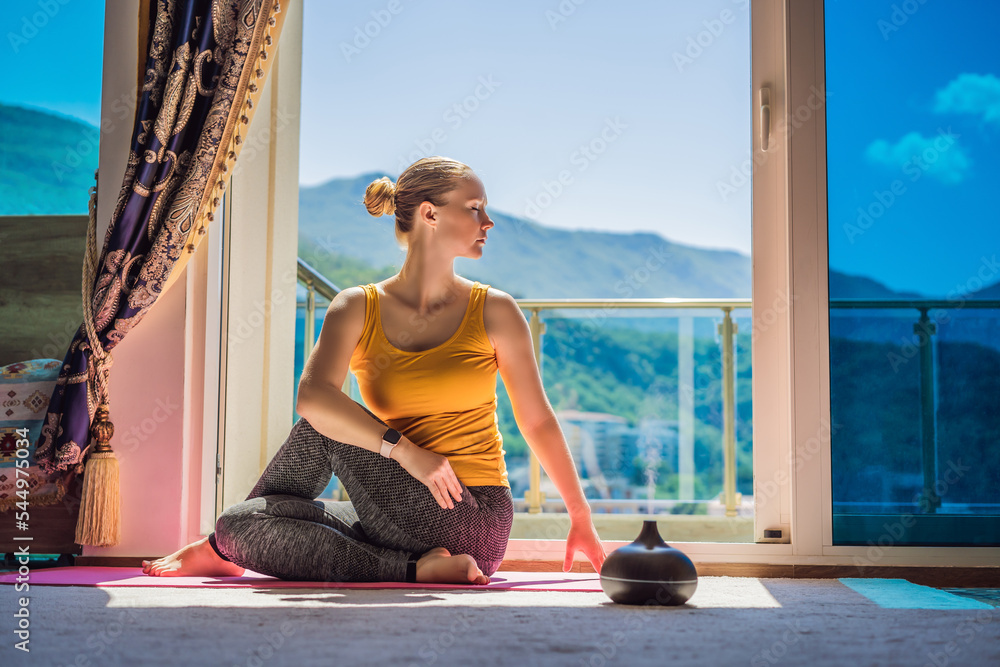 Mindful healthy woman practicing yoga at home. Sitting on the floor doing  yoga for mental balance relaxing on stress. Enjoying time uses an aroma  diffuser Stock Photo | Adobe Stock