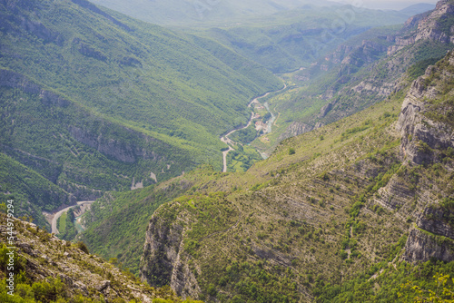 Blue river running through green valley toward distant mountains. Beautiful mountains of Montenegro and the river Cievna