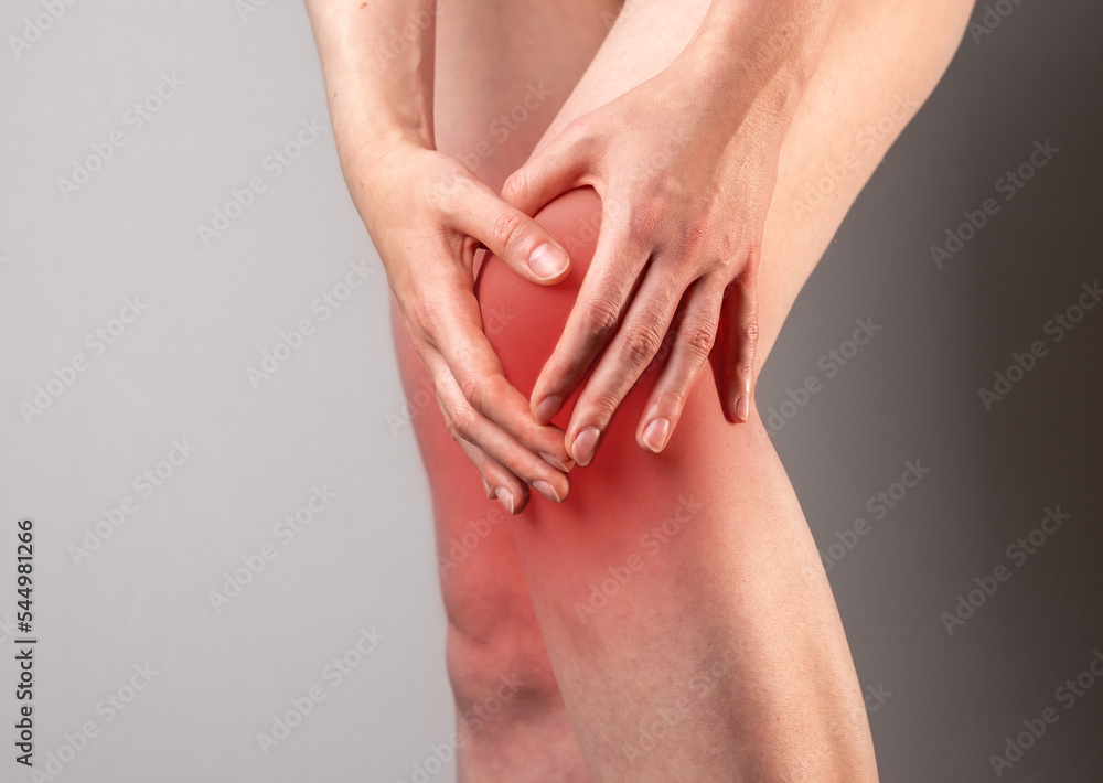 Kneecap ache, broken meniscus pain, leg joint trauma closeup. Hand massaging injury spot