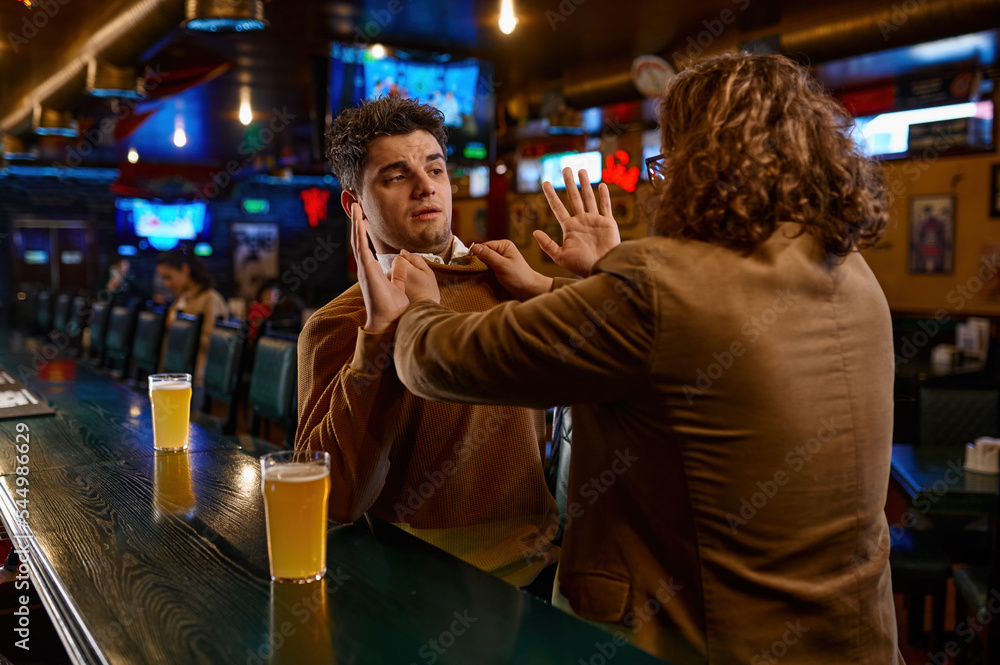 Two football fans fighting at sport bar counter