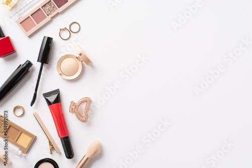 Decorative cosmetics concept. Top view photo of red lip gloss nail polish mascara eyeshadow palettes brush gold rings and barrettes on isolated white background with empty space