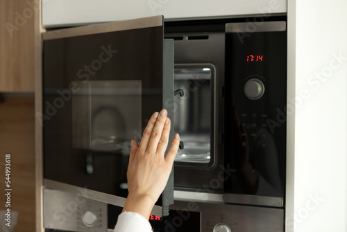 Woman s hand uses a microwave