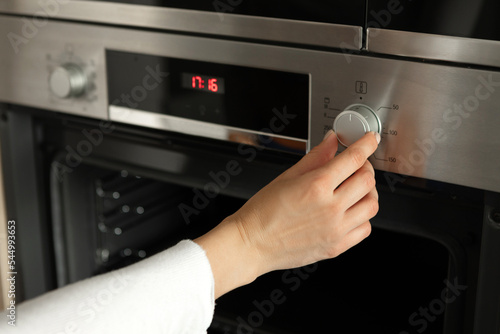 Woman regulates the temperature of the oven 