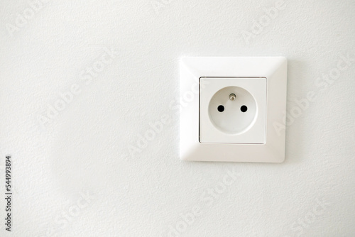Electric socket isolated on a white wall. Empty copy space