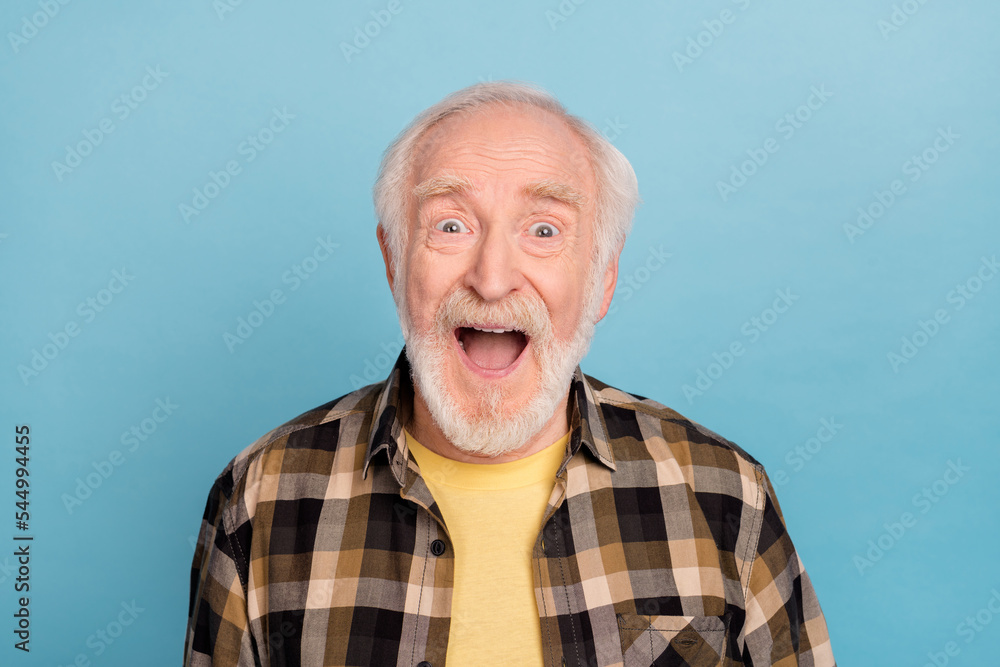 Photo of pretty impressed retired man wear plaid shirt smiling open mouth isolated blue color background