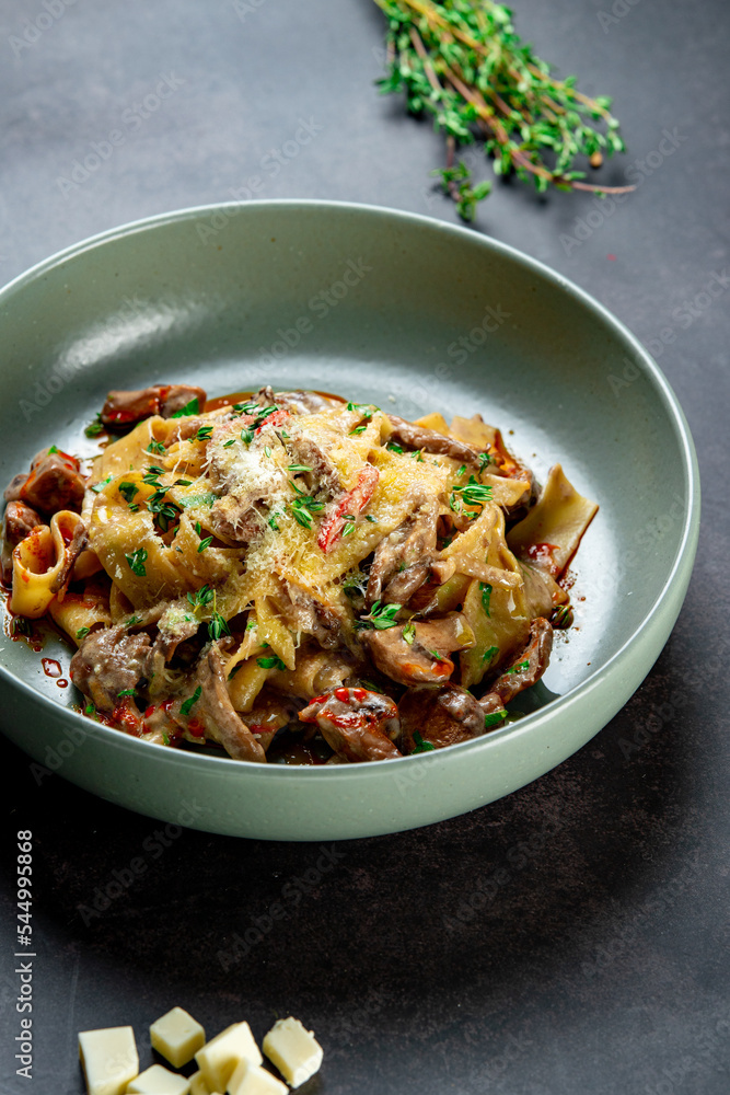 Pasta Bolognese with spices, Italian pasta dish with minced meat and tomatoes in a dark plate on a stone background Pasta Bolognese with spices, Italian pasta dish with minced meat and tomatoes in a dark plate on a stone background