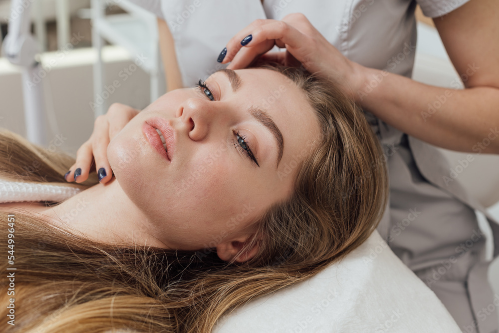 Fototapeta premium An expert cosmetologist performs an analysis of the patient's facial skin