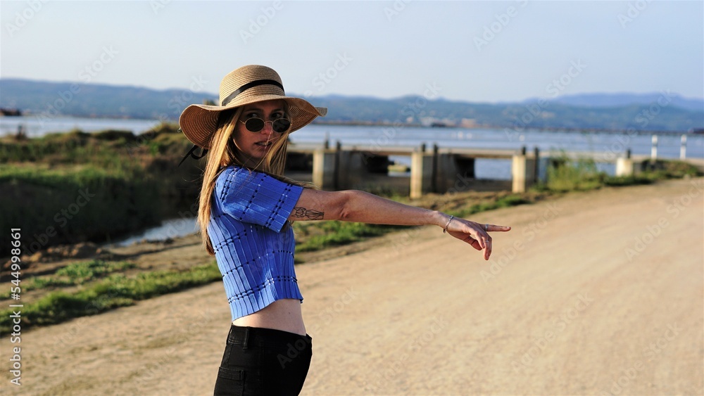 woman with hat pointing at park woman with hat pointing at park