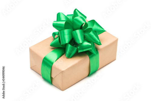 Close up shot of gift box wrapped in craft paper and decorated with green satin ribbon bow, isolated on white background © wpadington