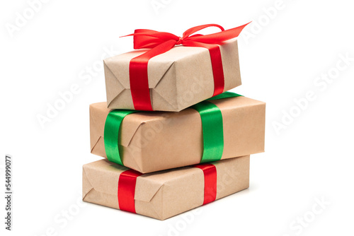 Close up set of three gift boxes wrapped in craft paper and decorated with satin ribbon bows, isolated on white background