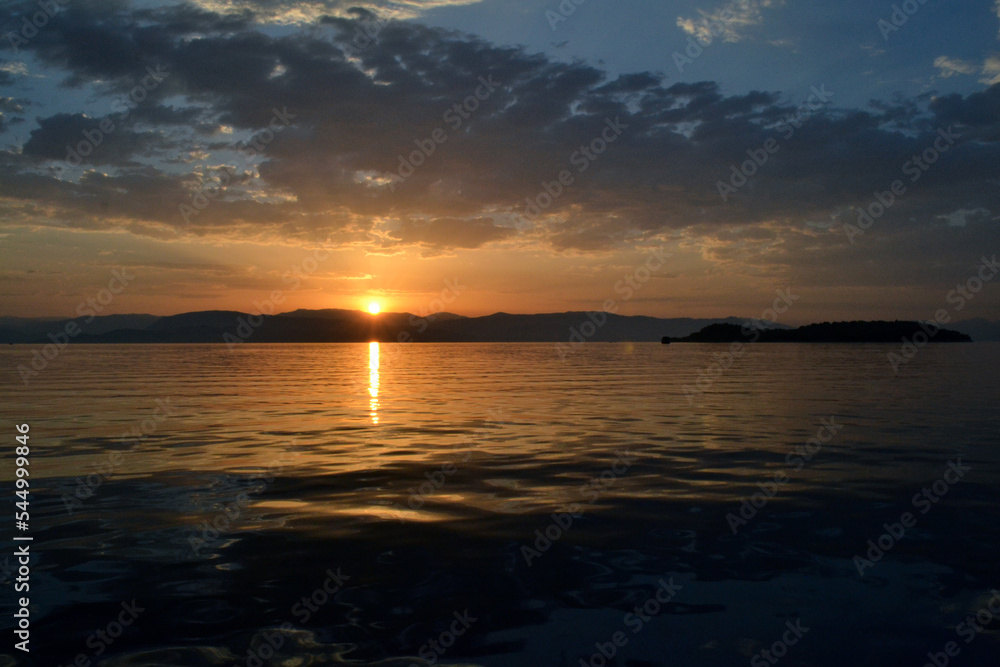 View of Albania and Lazareto island from a sailboat during sunrise.