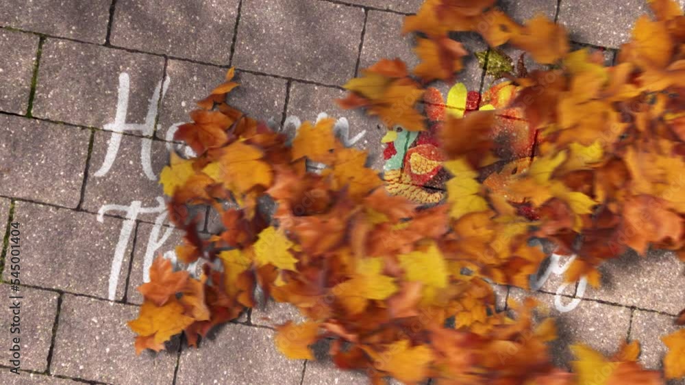 Pile of Maple Leaves Getting Blown With Wind and Revealing Happy Thanksgiving Message Written on Pavement. Pile of Maple Leaves Getting Blown With Wind and Revealing Happy Thanksgiving Message Written on Pavement.