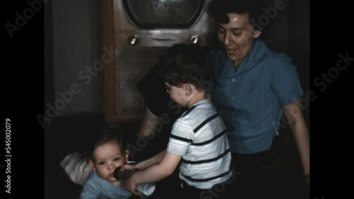 Feeding Baby Brother 1951 - A boy gives his baby brother a bottle in 1951.