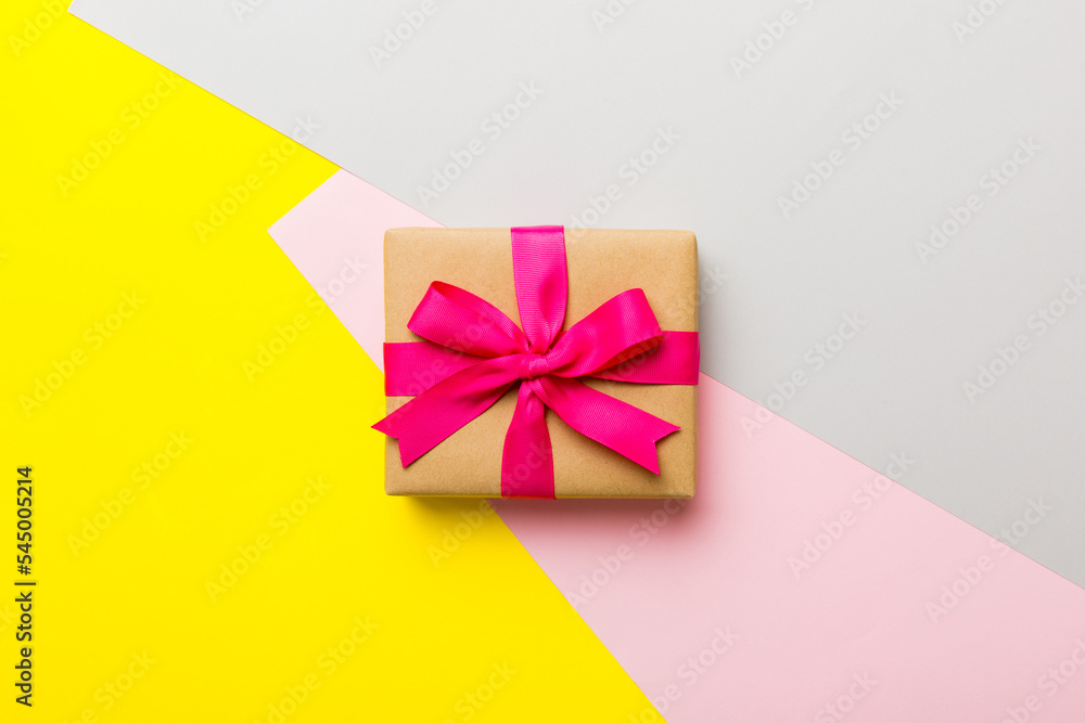 holiday paper present tied pink ribbon bow top view with copy space. Flat lay holiday background. Birthday or christmas present. Christmas gift box concept with copy space holiday paper present tied pink ribbon bow top view with copy space. Flat lay holiday background. Birthday or christmas present. Christmas gift box concept with copy space