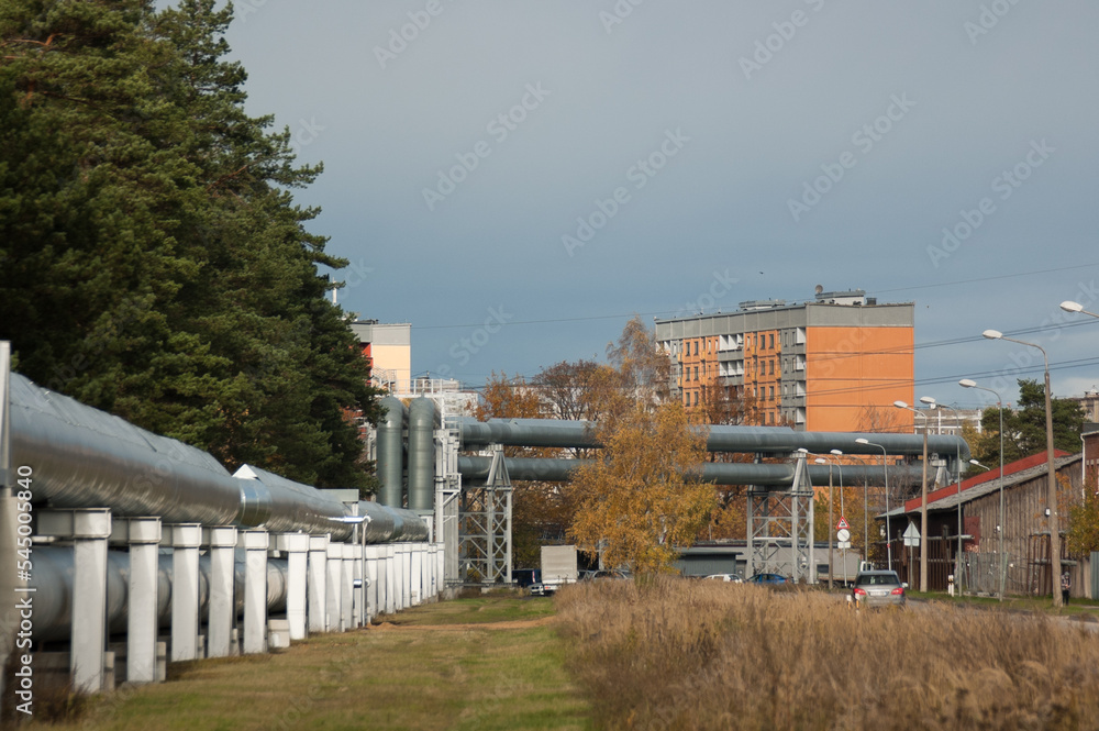 pipeline, in the photo the pipeline is close-up, in the background the city and buildings