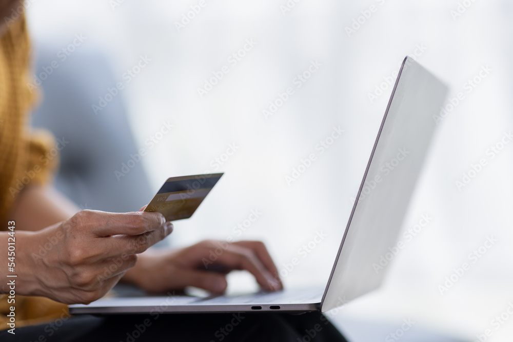 Close up of woman hand using credit card and laptop for payment and online shopping, Online shopping, payments digital banking, E-commerce concept. Close up of woman hand using credit card and laptop for payment and online shopping, Online shopping, payments digital banking, E-commerce concept.