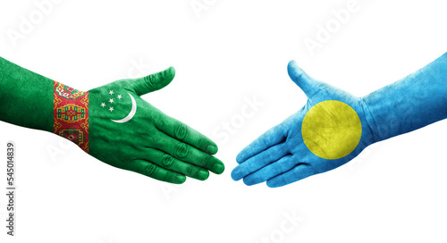 Handshake between Palau and Turkmenistan flags painted on hands, isolated transparent image.