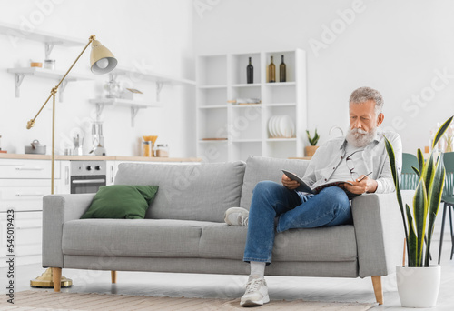 Senior bearded man reading ...