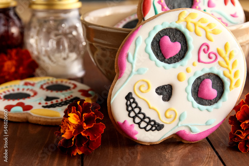 Bowl with skull shaped cookies on wooden background, closeup. El Dia de Muertos