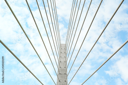 Beautiful modern bridge against blue cloudy sky, low angle view